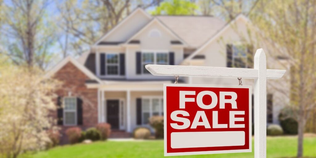 for sale sign in front of house